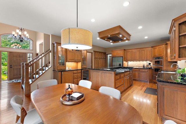 11582 Raspberry Hill Rd, Eden Prairie, MN 55344 - dining room with a chandelier, light wood finished floors, wine cooler, recessed lighting, and stairs