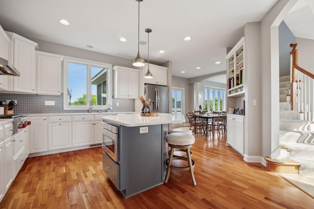 11540 Eckert Ave SE, Franklin Twp, MN 55328 - kitchen with stainless steel appliances, light wood-style flooring, a kitchen island, white cabinetry, and recessed lighting