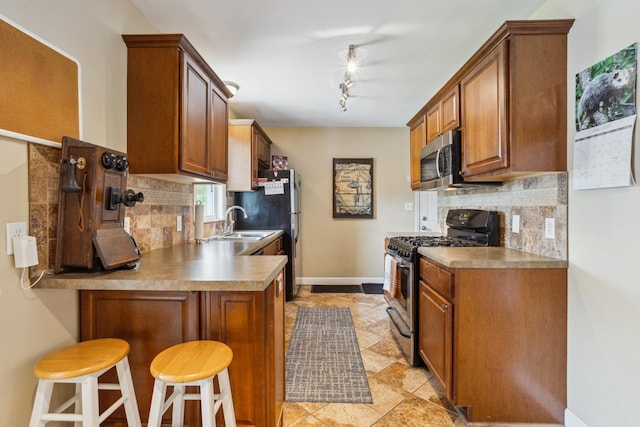 6342 Baker Ave NE, Fridley, MN 55432 - kitchen featuring appliances with stainless steel finishes, decorative backsplash, a peninsula, and brown cabinetry