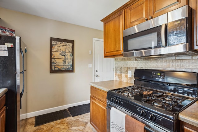6342 Baker Ave NE, Fridley, MN 55432 - kitchen with stainless steel appliances, backsplash, brown cabinets, and light countertops