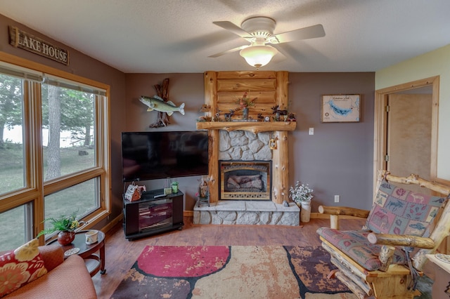 35139 County 39, Laporte, MN 56461 - living area with a fireplace, wood finished floors, ceiling fan, and a textured ceiling