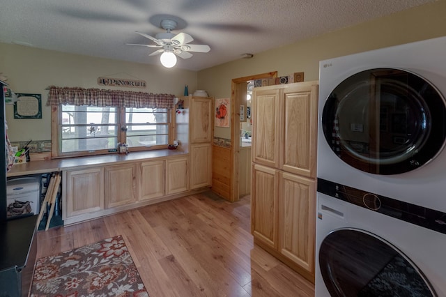 35139 County 39, Laporte, MN 56461 - washroom featuring stacked washer and clothes dryer, ceiling fan, light wood-style floors, a textured ceiling, and cabinet space