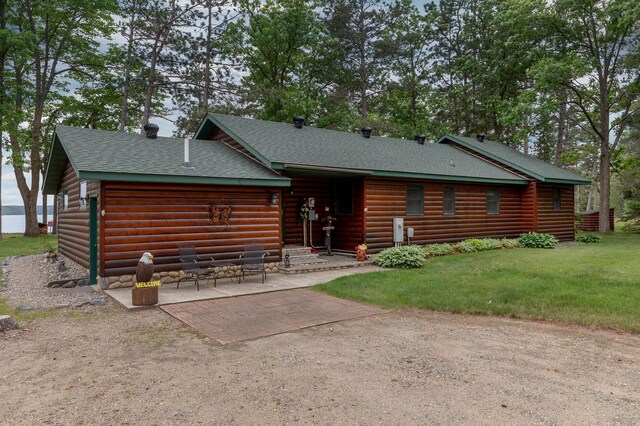 35139 County 39, Laporte, MN 56461 - cabin featuring a shingled roof, a front yard, a patio, and faux log siding