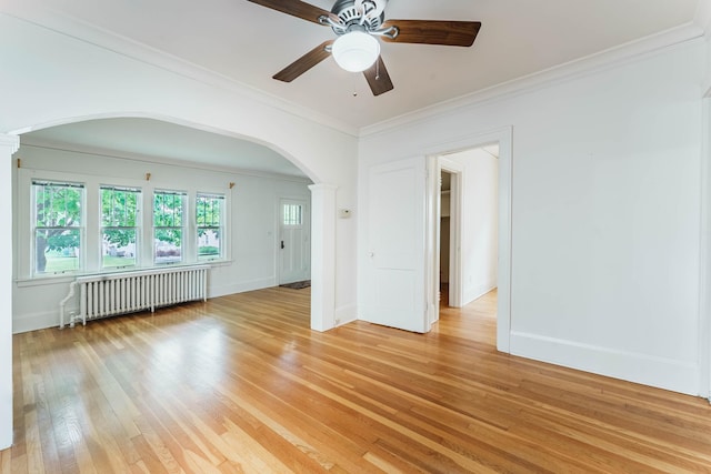 1787 Randolph Ave, Saint Paul, MN 55105 - unfurnished room featuring radiator heating unit, arched walkways, light wood-style floors, ceiling fan, and ornate columns