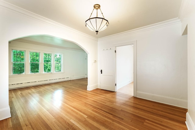 1787 Randolph Ave, Saint Paul, MN 55105 - unfurnished room with baseboard heating, arched walkways, hardwood / wood-style floors, and crown molding