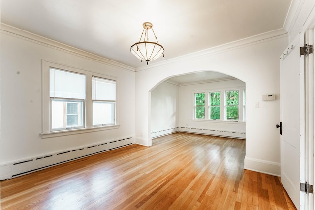 1787 Randolph Ave, Saint Paul, MN 55105 - spare room with a baseboard radiator, arched walkways, ornamental molding, and light wood-style flooring