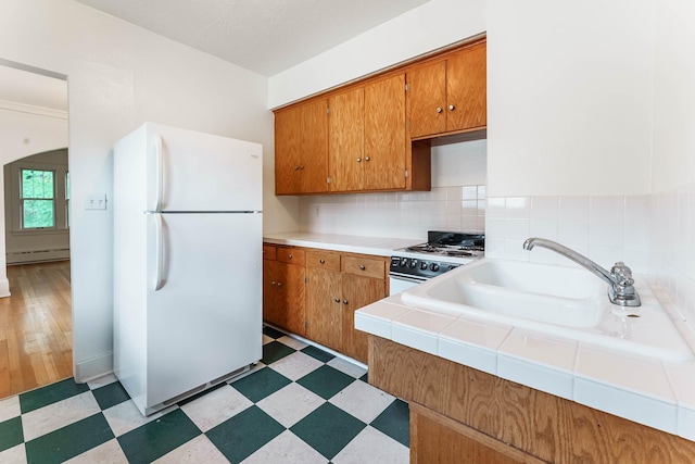 1787 Randolph Ave, Saint Paul, MN 55105 - kitchen with white appliances, brown cabinetry, light flooring, a baseboard radiator, and tile countertops