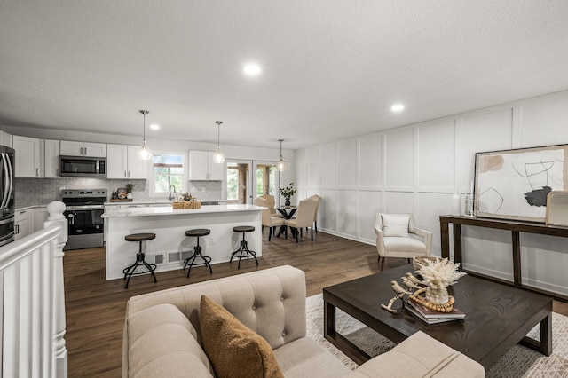 4909 98th St, Bloomington, MN 55437 - living area with a decorative wall, dark wood-style flooring, and recessed lighting