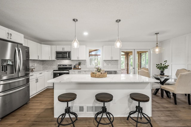 4909 98th St, Bloomington, MN 55437 - kitchen with stainless steel appliances, backsplash, and a breakfast bar area