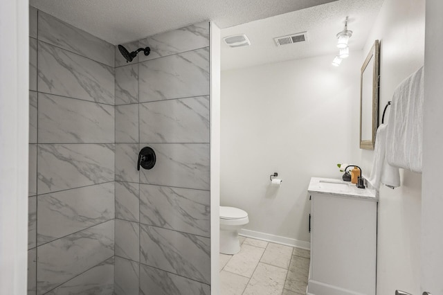 4909 98th St, Bloomington, MN 55437 - bathroom featuring vanity, a tile shower, a textured ceiling, and marble finish flooring