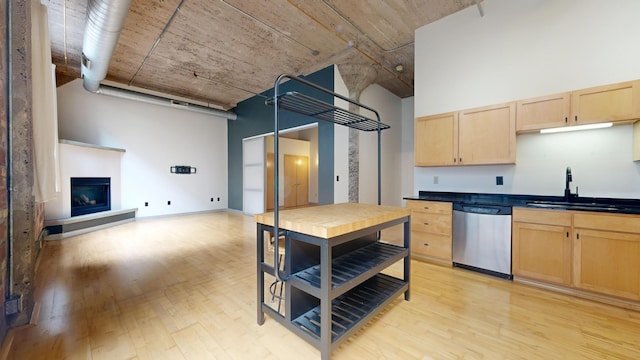 521 7th St Unit 519, Minneapolis, MN 55415 - kitchen featuring dishwasher, light brown cabinets, light wood-style floors, a glass covered fireplace, and a high ceiling