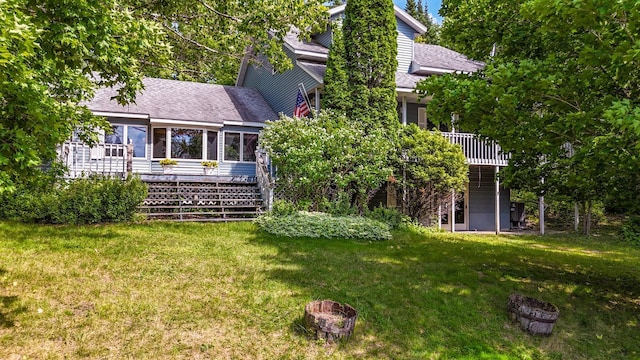 39130 Notebloom Ln, Waubun, MN 56589 - rear view of property with roof with shingles, a wooden deck, a lawn, stairs, and a sunroom