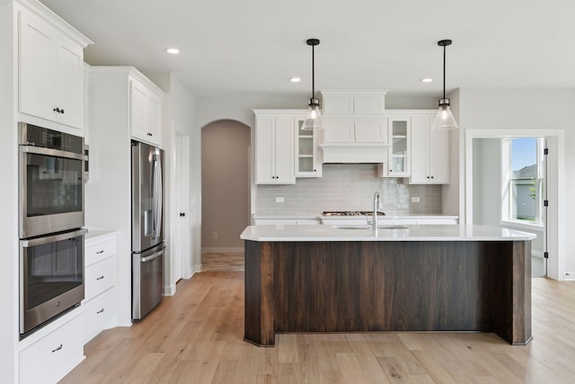 4720 131st Ave NE, Blaine, MN 55449 - kitchen featuring stainless steel appliances, light countertops, arched walkways, light wood finished floors, and recessed lighting