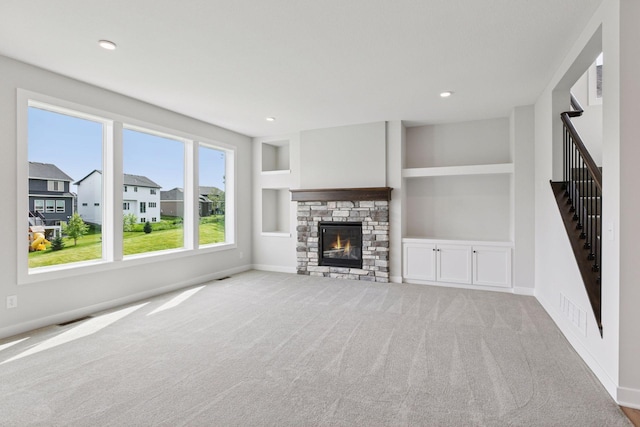 4720 131st Ave NE, Blaine, MN 55449 - unfurnished living room with carpet, a stone fireplace, built in shelves, recessed lighting, and stairs