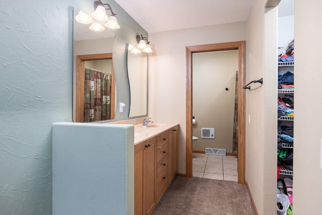 N8343 Mcwain Dr, Holland Twp, WI 54636 - bathroom featuring vanity, tile patterned flooring, and a walk in closet