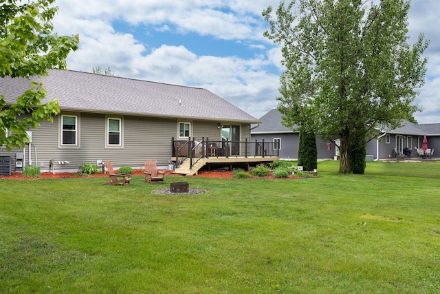 N8343 Mcwain Dr, Holland Twp, WI 54636 - rear view of property with a fire pit, a wooden deck, a yard, and roof with shingles
