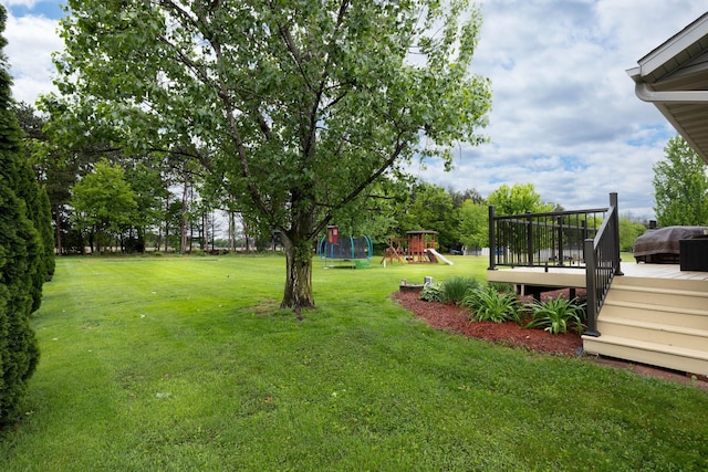 N8343 Mcwain Dr, Holland Twp, WI 54636 - view of green lawn featuring a playground and a wooden deck