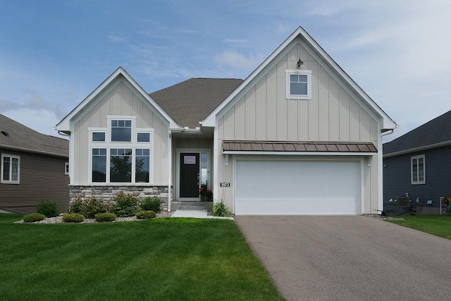 1872 Oakpointe Dr, Waconia, MN 55387 - view of front of home with board and batten siding, driveway, a front yard, and stone siding