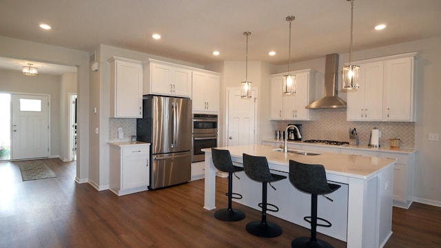 1872 Oakpointe Dr, Waconia, MN 55387 - kitchen with appliances with stainless steel finishes, wall chimney exhaust hood, dark wood-type flooring, a kitchen breakfast bar, and tasteful backsplash