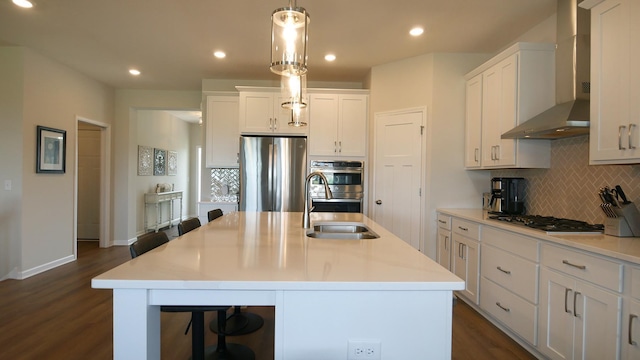 1872 Oakpointe Dr, Waconia, MN 55387 - kitchen with wall chimney exhaust hood, appliances with stainless steel finishes, tasteful backsplash, white cabinets, and dark wood-style flooring