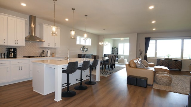 1872 Oakpointe Dr, Waconia, MN 55387 - kitchen featuring wall chimney exhaust hood, open floor plan, dark wood-style floors, a kitchen island with sink, and backsplash