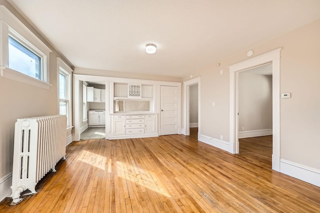 3148 Pleasant Ave, Minneapolis, MN 55408 - unfurnished bedroom with radiator heating unit, light wood-style flooring, and ensuite bathroom