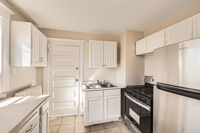 3148 Pleasant Ave, Minneapolis, MN 55408 - kitchen with appliances with stainless steel finishes, white cabinetry, light tile patterned floors, and light countertops