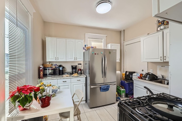 3148 Pleasant Ave, Minneapolis, MN 55408 - kitchen with appliances with stainless steel finishes, white cabinetry, light countertops, and light tile patterned flooring