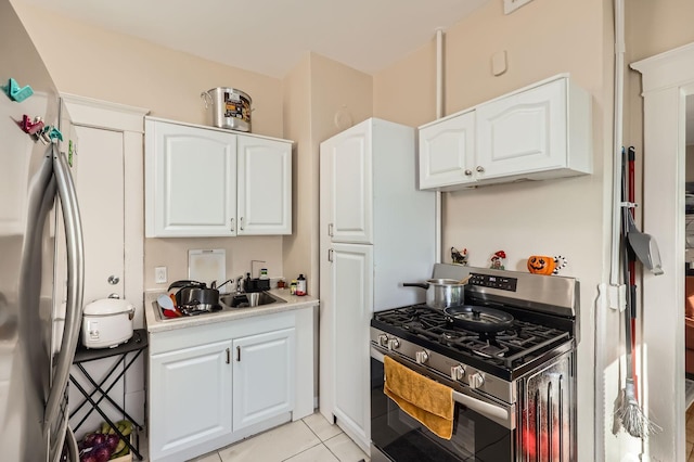 3148 Pleasant Ave, Minneapolis, MN 55408 - kitchen with stainless steel appliances, light countertops, white cabinets, and light tile patterned floors