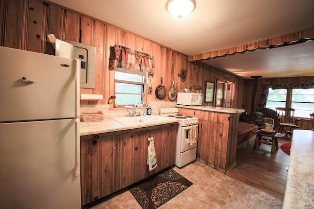 1962 81st St, Balsam Lake, WI 54810 - kitchen featuring white appliances, light countertops, a peninsula, electric panel, and wood walls