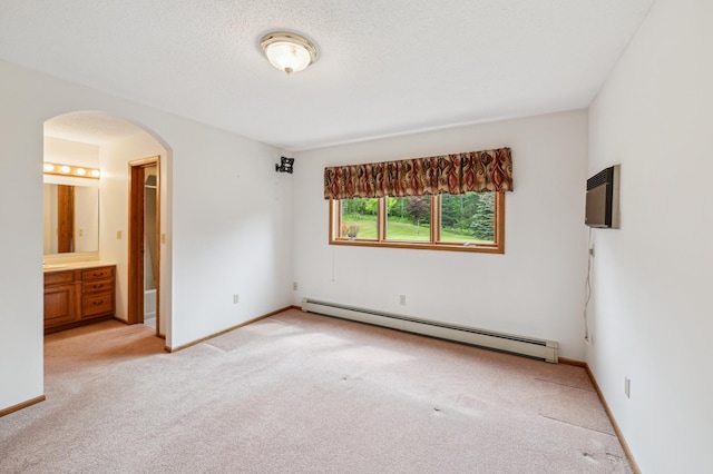5948 Lavaque Rd, Fredenberg Twp, MN 55803 - unfurnished bedroom featuring baseboard heating, arched walkways, light colored carpet, and ensuite bathroom