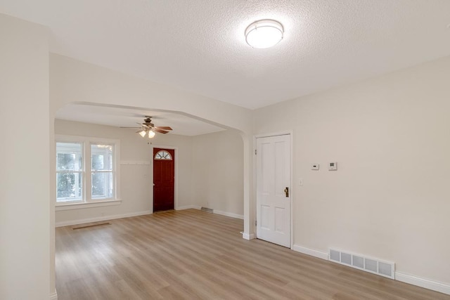 500 Sherman St, North Mankato, MN 56003 - unfurnished room with arched walkways, a ceiling fan, light wood-type flooring, and a textured ceiling