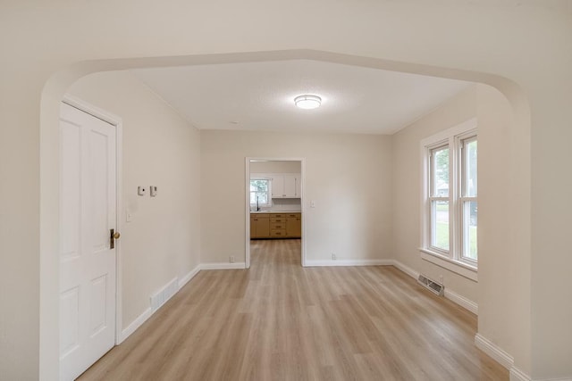 500 Sherman St, North Mankato, MN 56003 - empty room with light wood-style flooring, arched walkways, and healthy amount of natural light