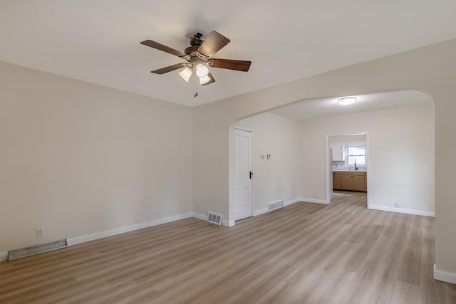500 Sherman St, North Mankato, MN 56003 - empty room with arched walkways, ceiling fan, and light wood-type flooring