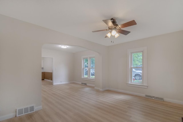 500 Sherman St, North Mankato, MN 56003 - spare room featuring arched walkways, plenty of natural light, and light wood-style floors