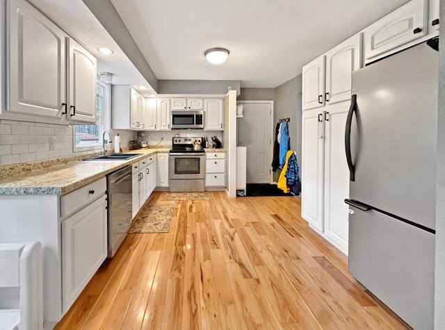 315 32nd St, Grand Rapids, MN 55744 - kitchen with appliances with stainless steel finishes, light wood-style flooring, white cabinets, and recessed lighting