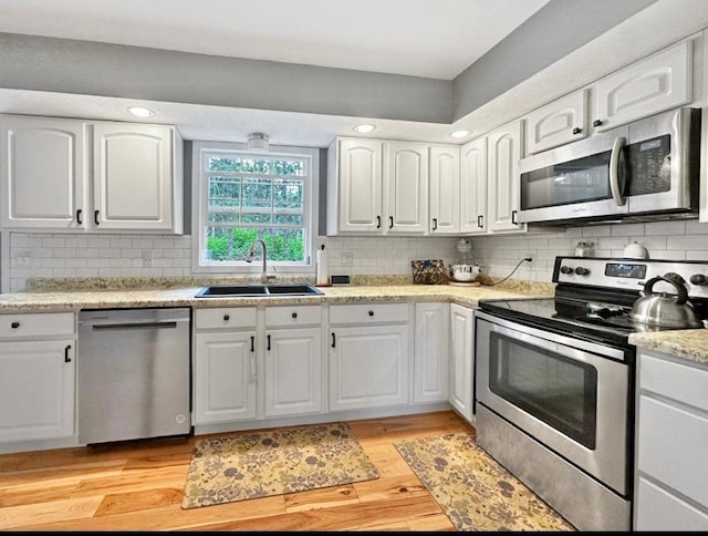 315 32nd St, Grand Rapids, MN 55744 - kitchen featuring stainless steel appliances, white cabinetry, decorative backsplash, and recessed lighting