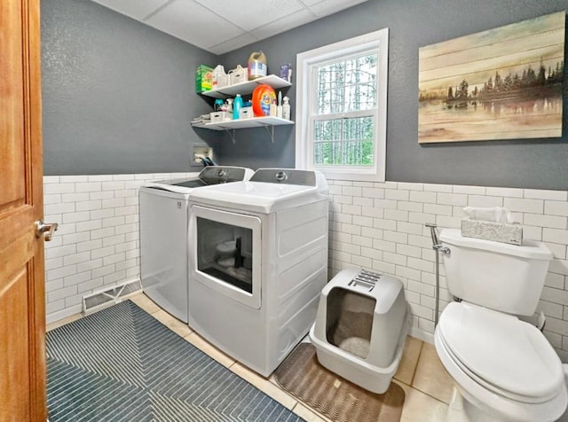 315 32nd St, Grand Rapids, MN 55744 - laundry area with washing machine and dryer, tile walls, tile patterned floors, and wainscoting