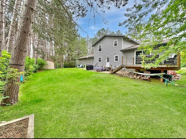 315 32nd St, Grand Rapids, MN 55744 - rear view of property featuring a deck, a lawn, a storage unit, and stairs