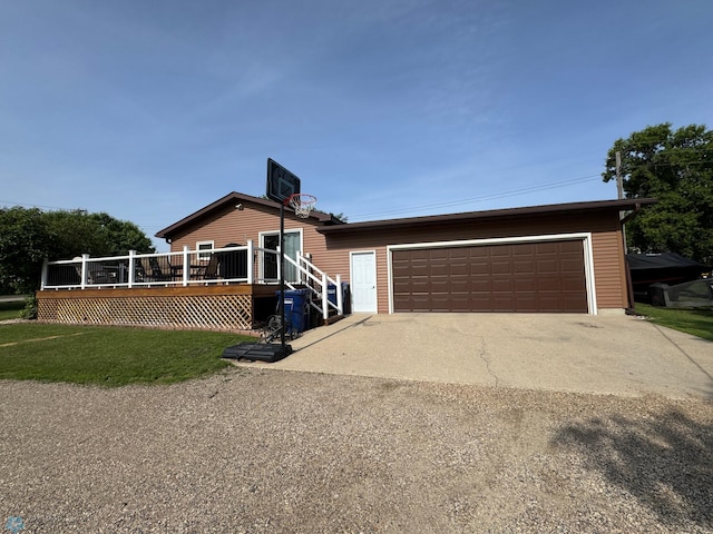 418 4th Ave W, Lisbon, ND 58054 - view of front facade featuring a wooden deck, a garage, driveway, and a front yard
