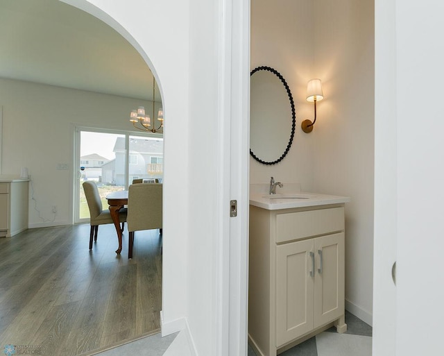 7328 Aquiline Dr S, Fargo, ND 58104 - bathroom with wood finished floors, vanity, and a chandelier