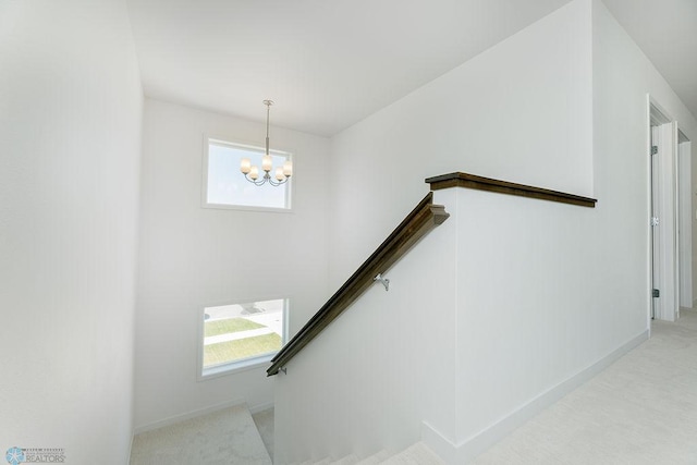 7328 Aquiline Dr S, Fargo, ND 58104 - stairway with plenty of natural light, a chandelier, and carpet floors