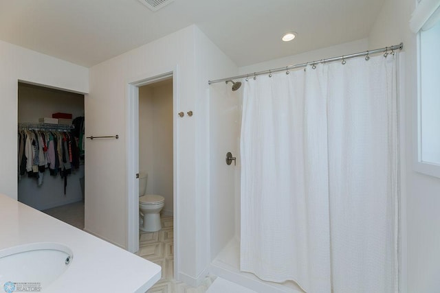 7328 Aquiline Dr S, Fargo, ND 58104 - bathroom featuring a shower with shower curtain, vanity, recessed lighting, and a spacious closet