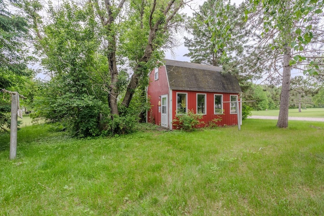 196 Beaulieu St W, Motley, MN 56466 - view of front of house with a gambrel roof, an outbuilding, a front lawn, and roof with shingles