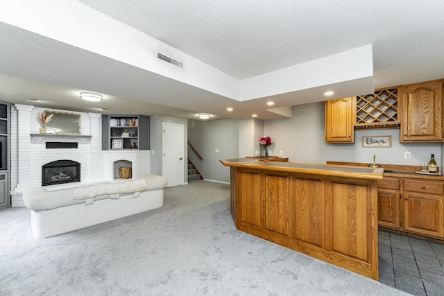 5520 25th Ave NW, Rochester, MN 55901 - kitchen featuring open floor plan, a fireplace, a textured ceiling, light carpet, and a center island