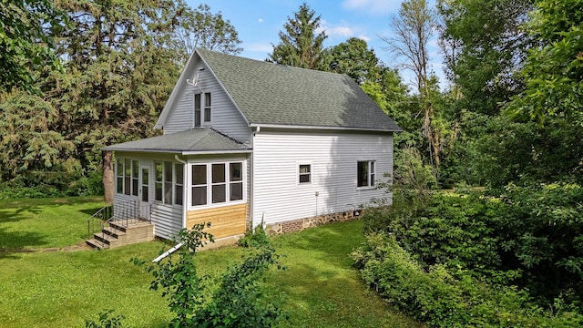 W3767 750th Ave, Gilman Twp, WI 54767 - view of side of home with roof with shingles, a lawn, and a sunroom