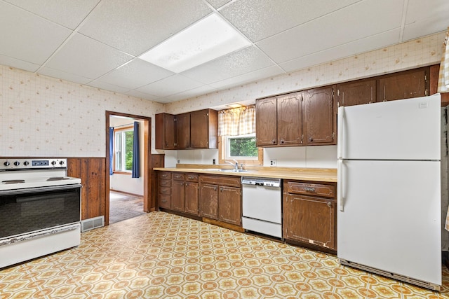 W3767 750th Ave, Gilman Twp, WI 54767 - kitchen featuring white appliances, a paneled ceiling, wallpapered walls, plenty of natural light, and light countertops
