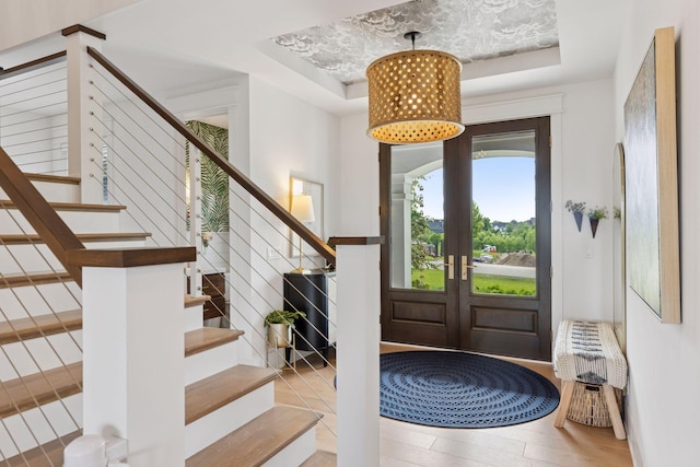 7568 Glen Alcove, Woodbury, MN 55129 - foyer entrance featuring a tray ceiling, stairway, wood finished floors, and french doors