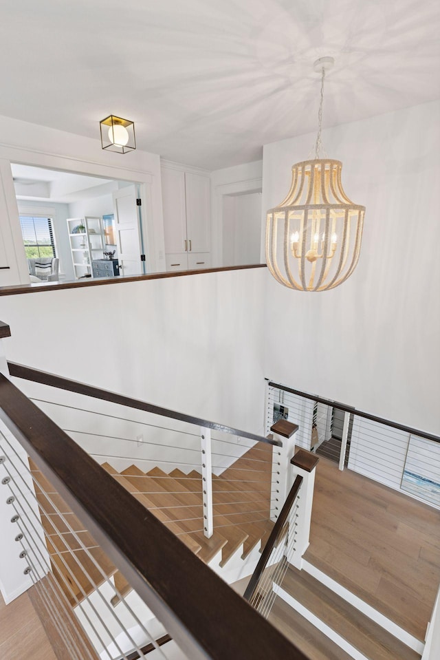 7568 Glen Alcove, Woodbury, MN 55129 - staircase featuring a chandelier and wood finished floors