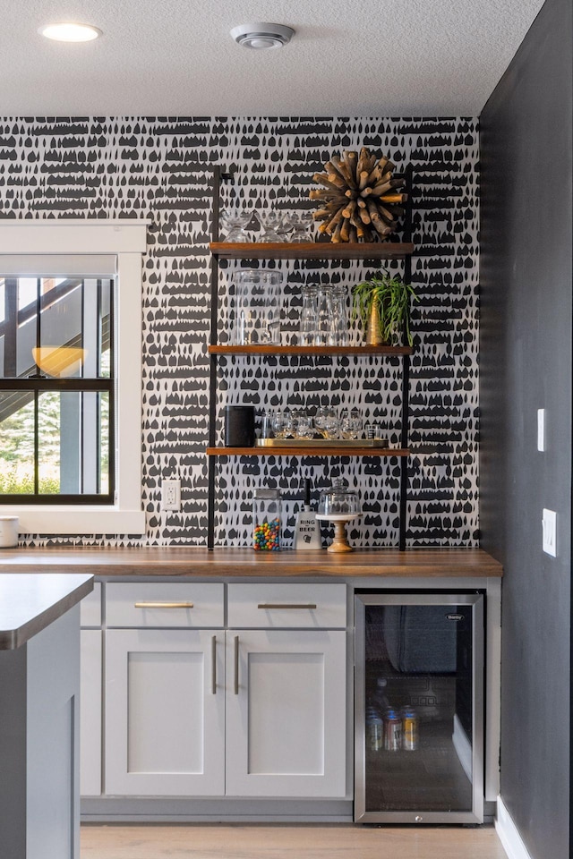 7568 Glen Alcove, Woodbury, MN 55129 - indoor dry bar featuring beverage cooler and a textured ceiling